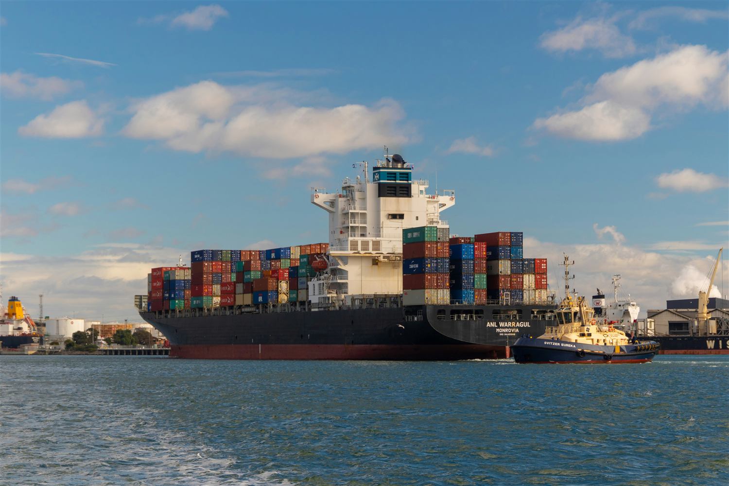 Cargo ship alongside a working port